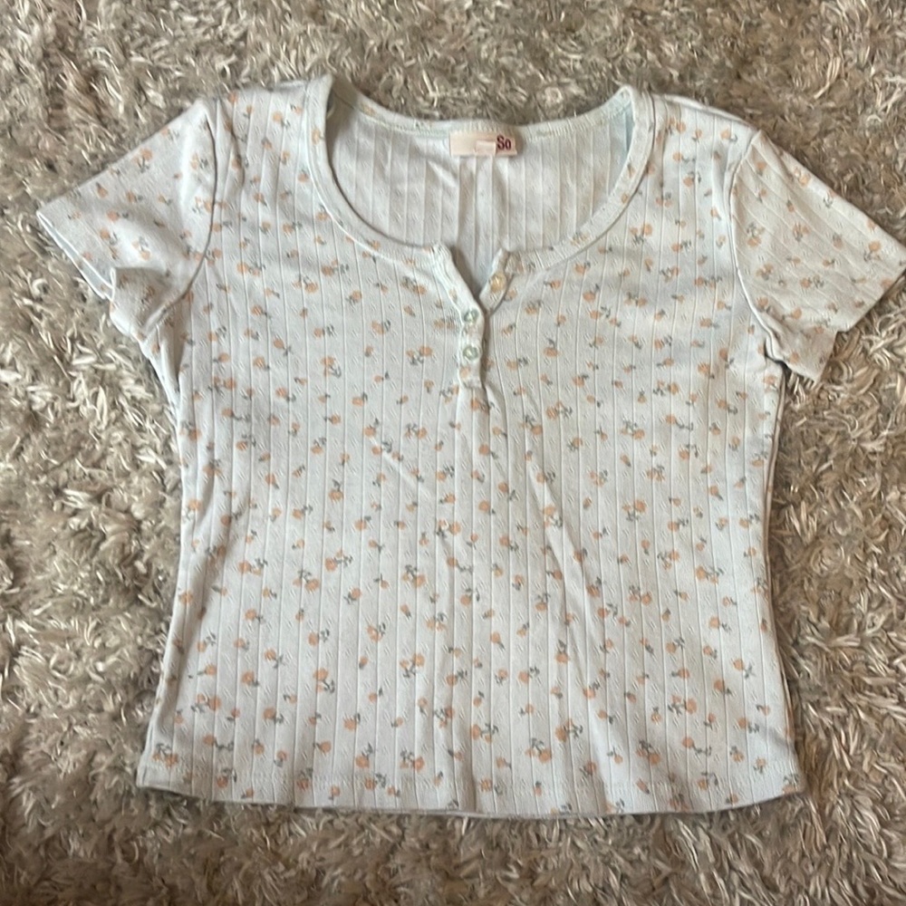 light blue, cropped shirt with a flower pattern